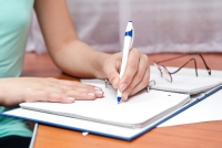 En person som skriver på et stykke papir